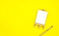 Drawing equipment, wooden easel with blank canvas and brush isolated on a yellow background Royalty Free Stock Photo