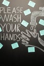 Drawing of a hand wash on the blackboard with chalk and the inscription -Please wash your hands with the virus stickers.