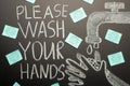Drawing of a hand wash on the blackboard with chalk and the inscription -Please wash your hands with the virus stickers.