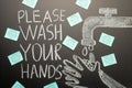 Drawing of a hand wash on the blackboard with chalk and the inscription -Please wash your hands with the virus stickers.