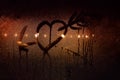 A drawing of a heart pierced by Cupid`s arrow on the sweaty glass of the car in backlit city lights