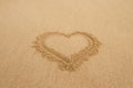 Drawing a heart on wet golden beach sand Royalty Free Stock Photo