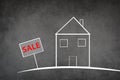 Drawing of a house on a chalkboard, the word sale is standing on the sign