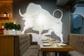 A large white bull is painted on the wall in a restaurant