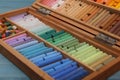 Drawing pastel set in wooden box light blue table, closeup