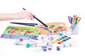 Drawing a picture, female hand close-up, stationery, paint brushes, on a white background