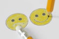 Drawing of smiley face with positive and negative expression with pencil and rubber - Positivity concept