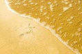 A drawing of the sun made on a sandy beach flooded by the sea wave Royalty Free Stock Photo