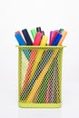 Drawing supplies concept. Photo of colorful markers in yellow pencil cup isolated on white background Royalty Free Stock Photo