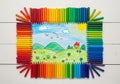 Drawing is surrounded by an array of crayons arranged in a rainbow Royalty Free Stock Photo