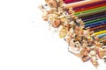 Drawing tools background. Lot of colorful pencils frame with sawdust and shavings on white Royalty Free Stock Photo