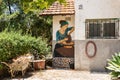 Drawing on the wall depicting a woman making a jug on a potter wheel on the wall of one of the buildings in Zikhron Yaakov city in