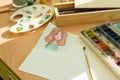 Drawing by watercolor - anime girl, on a table with watercolor paint brush