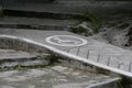 Drawing of a wheelchair symbol on a concrete ramp in a park. Ramps for wheelchairs with sign and wooden railing Royalty Free Stock Photo