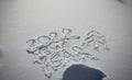 Drawing on white snow in sunlight. New Year`s date, Christmas figures 2022, close-up. Winter holiday concept