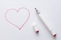 Drawn by a bright red felt-tip pen or marker a red heart on white paper and a white background. Love, romance, valentines day.