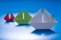 Drawn man looking through spyglass on Paper Boat Sailing with other on Blue paper sea with Drawn Details. Origami Ship Royalty Free Stock Photo