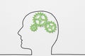 Drawn outline of human head with green clockwork as a working brain. Royalty Free Stock Photo