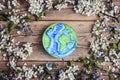 Drawn planet Earth with apple blossom and forget-me-not flowers on old wooden boards