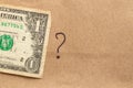 A drawn question mark and one dollar lie on brown paper Royalty Free Stock Photo