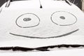 Drawn smile face on a snow covered windshield of a car Royalty Free Stock Photo