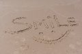 Drawn smile symbol and word smile written in beach sand with blue sea and waves in background Royalty Free Stock Photo