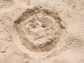 Drawn smiley face in summer beach sand. Painted head in dray salt sand. Royalty Free Stock Photo