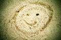 Drawn smiley face in summer beach sand. Painted head in dray salt sand. Royalty Free Stock Photo