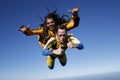 A dreadlocked instructor and a student jump tandem parachute in bliss.