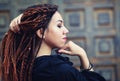 Dreadlocks closeup, fashionable girl posing at old wooden door background