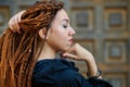 Dreadlocks closeup, fashionable girl posing at old wooden door background