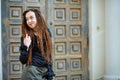 Dreadlocks fashionable girl posing at old wooden door background