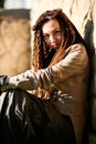 Dreadlocks fashionable girl posing in very bright sun with hard light