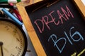 Dream big on phrase colorful handwritten on chalkboard, alarm clock with motivation and education concepts Royalty Free Stock Photo