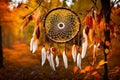 A dream catcher framed by the vibrant hues of autumn leaves, with a soft breeze causing the feathers to sway gently in the forest