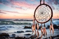 A dream catcher gently swaying in a coastal breeze, against a backdrop of crashing waves and a pastel-colored sky during twilight