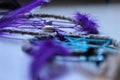 Closeup of purple and black handmade dreamcatcher with feathers