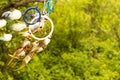 Dream catchers evolve in the wind, against a blurred green background of plants with copy space, symbol, tradition