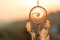 Dream cathcher amulet with sunset in background.Dream catcher is a handmade willow hoop woven to a web or literally includes such