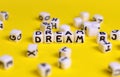 Dream concept. Cubes with `Dream` word and other defocused cubes. Make dreams come true idea.