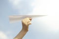 Dream concept of a person flying a paper plane in the sky