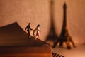 Dream Destination for Vacation. Travel in Paris, France. a Miniature Tourist Family Standing on the Aged Book. the Eiffel Tower as