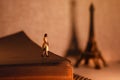 Dream Destination for Vacation. Travel in Paris, France. a Miniature Tourist Woman Standingon the Aged Book and Looking at the