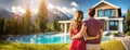 Dream Home with Pool Overlooking Mountains. A couple stands embracing in front of a luxurious house with a pool, looking Royalty Free Stock Photo