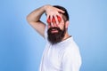 Dream of strawberry. Man can not see anything but strawberry blue background. Man bearded hipster hold hand with Royalty Free Stock Photo