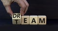 Dream team dreamteam symbol. Businessman turns wooden cubes and changes the word Dream to Team. Beautiful grey table grey