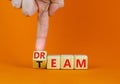 Dream team dreamteam symbol. Businessman turns wooden cubes and changes the word Dream to Team. Beautiful orange table orange Royalty Free Stock Photo