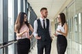 Dream team of three professional business people who discussing paperwork in modern office hallway Royalty Free Stock Photo