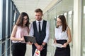 Dream team of three professional business people who discussing paperwork in modern office hallway Royalty Free Stock Photo