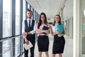 Dream team of three professional business people who discussing paperwork in modern office hallway Royalty Free Stock Photo